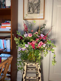 a vase of flowers sitting on a chair in a room