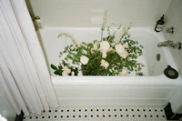 a bathtub with a vase of flowers in it