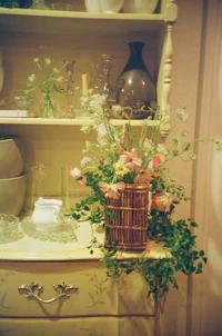 a wicker basket filled with flowers on a dresser