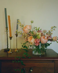 a vase of flowers sits on top of a dresser