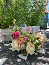 a bunch of flowers in a vase on the ground